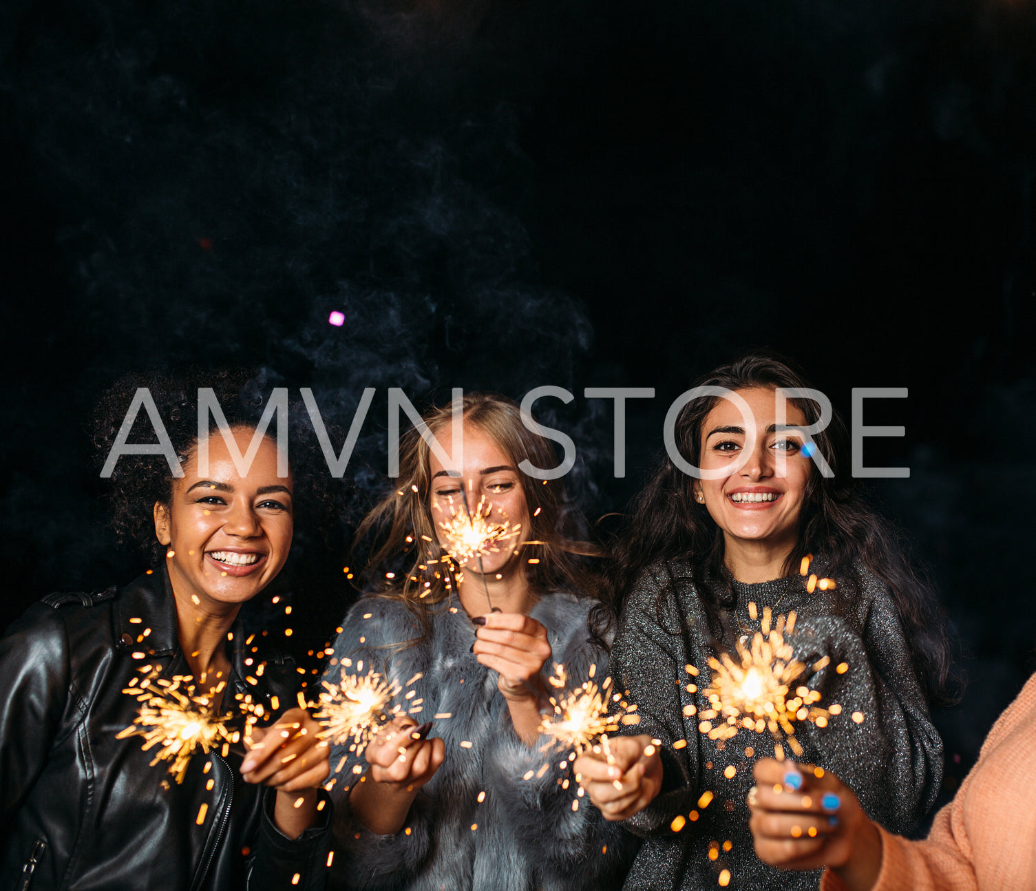 Three happy females with sparklers. Group of diverse female friends at night.