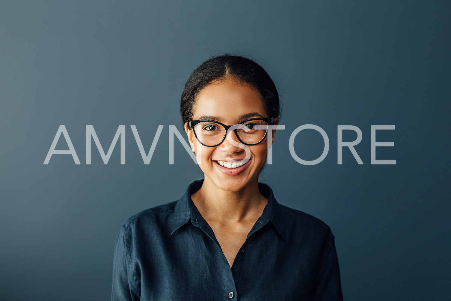 Portrait of a beautiful businesswoman wearing spectacles and looking at camera in living room	