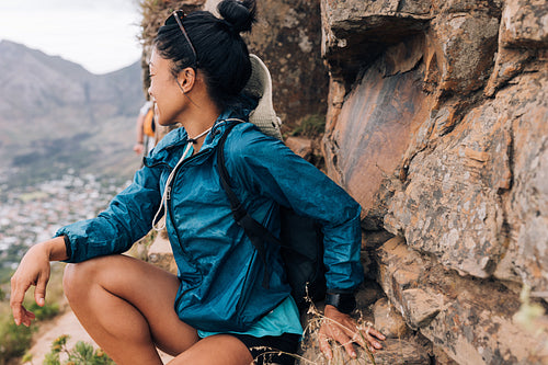 Woman sitting on a mountain looking away. Female hiker looking a