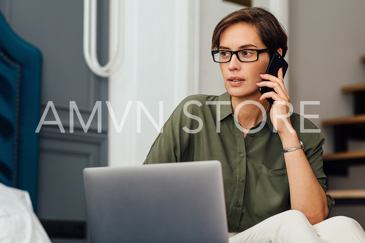 Woman entrepreneur on business trip working from hotel room sitting on a bed	