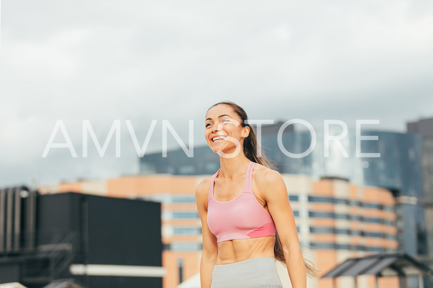 Happy female athlete in sportsclothes on the roof