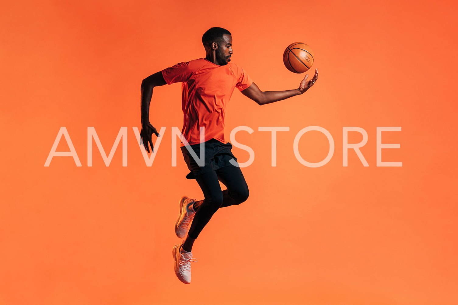 Side view of young male jumping and throwing up a basket ball in studio