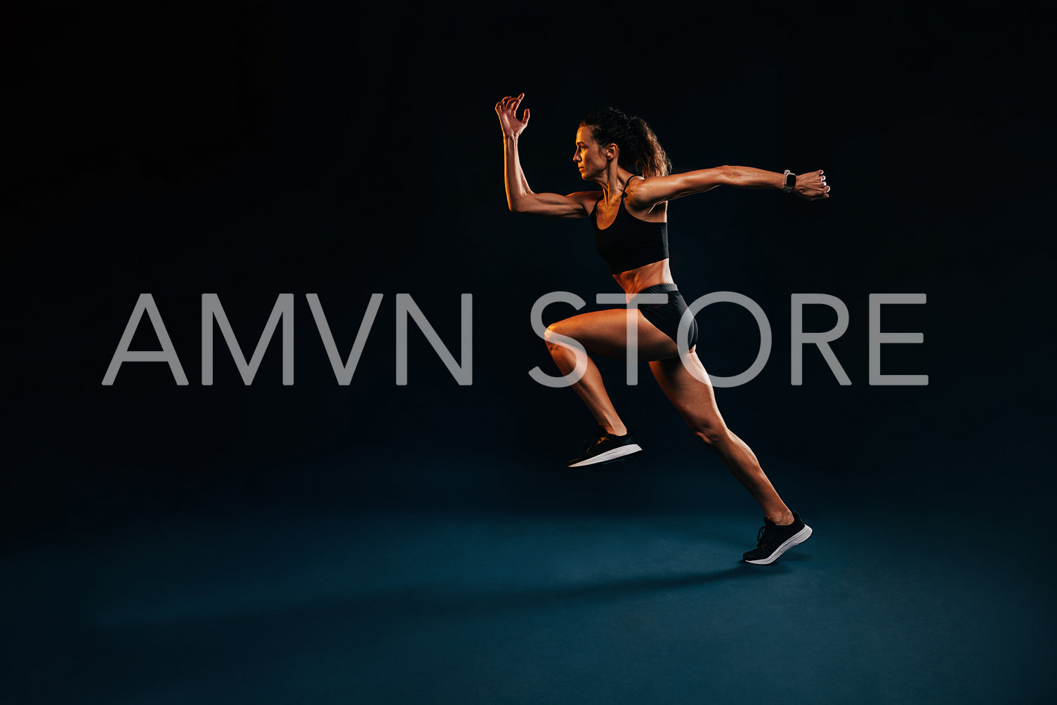 Muscular healthy woman running. Caucasian female runner in sportswear sprinting on black background.