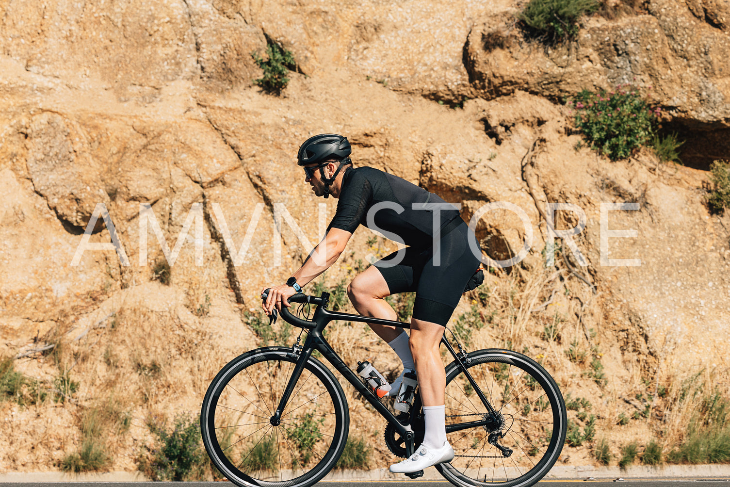 Side view a sportsman on a road bike against a hill a sunny day