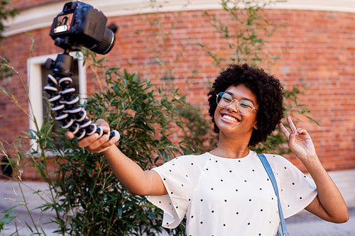 Happy girl filming on digital camera. Young vlogger making content.