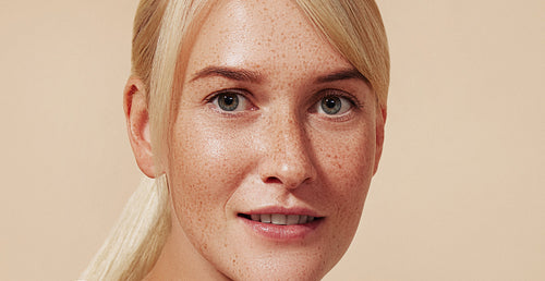 Cropped image of a young female with blond hair and freckled skin. High-detailed portrait of a beautiful young woman with smooth skin.