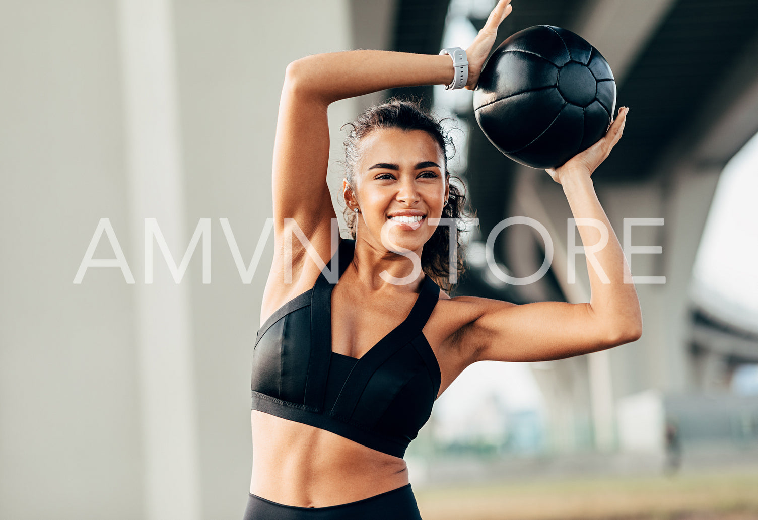 Young female doing warming up exercises with medicine ball	