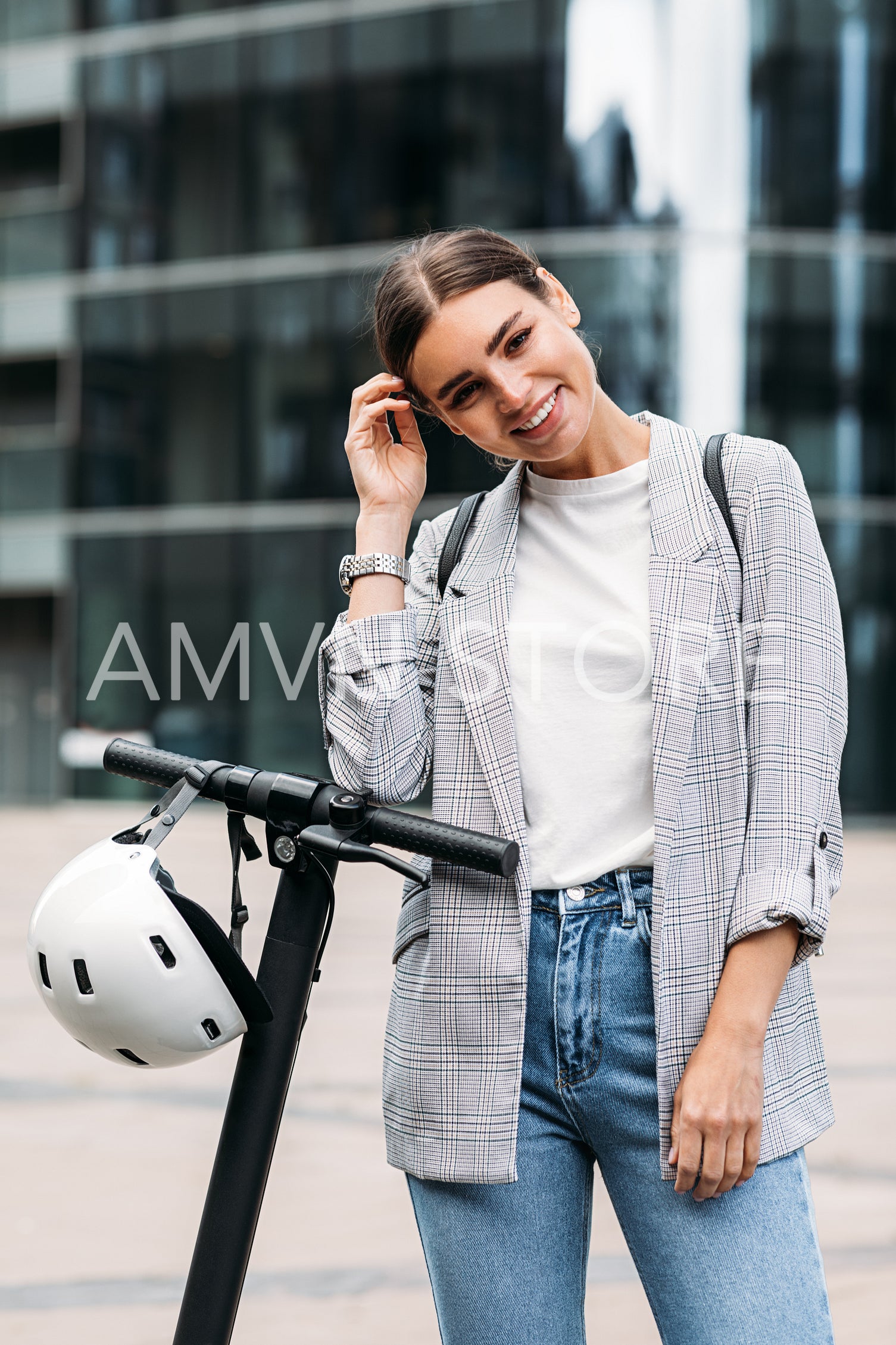 Smiling woman standing outdoors with electric scooter looking at camera