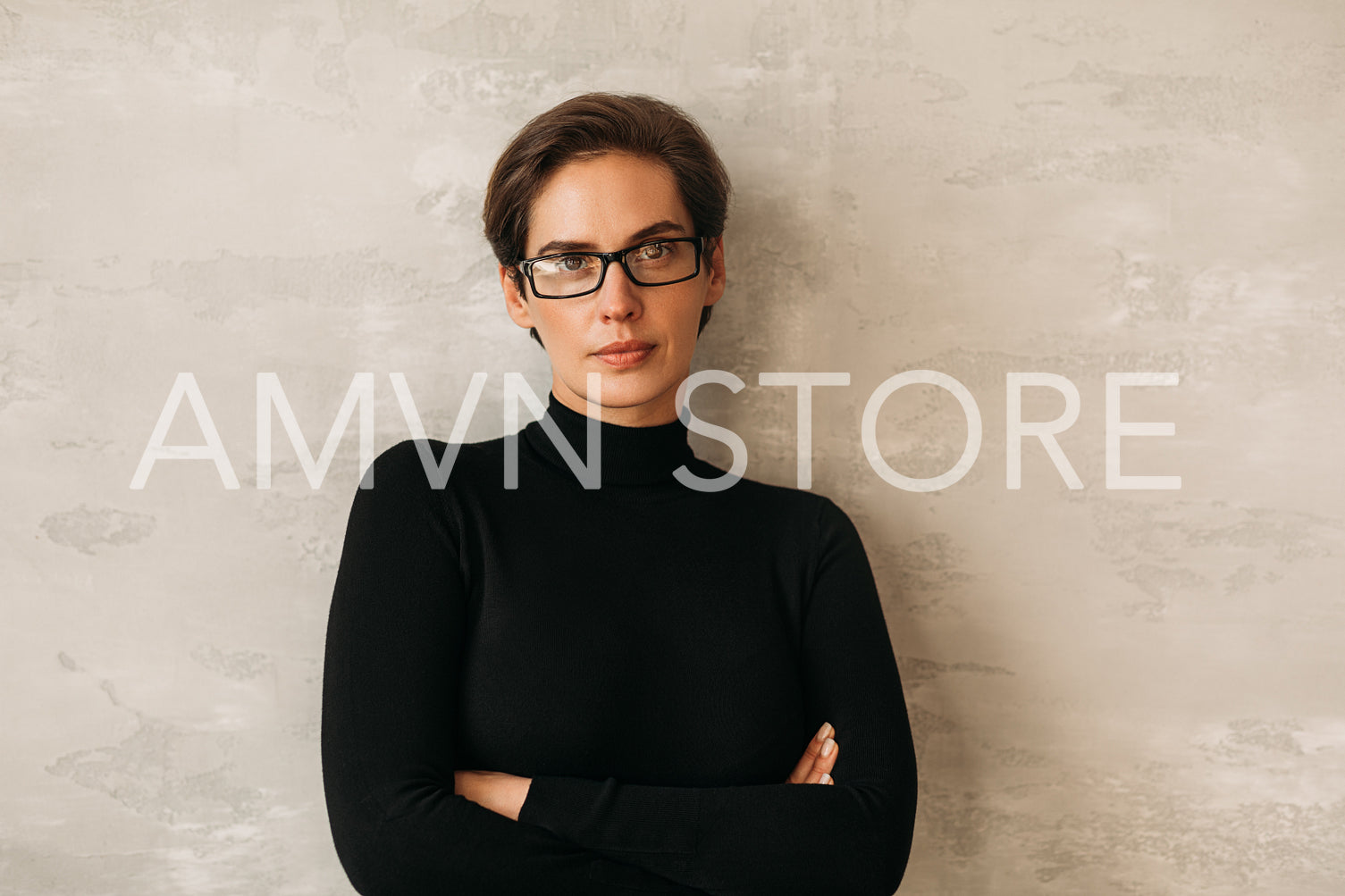 Businesswoman in formal clothes leaning on a wall with crossed arms