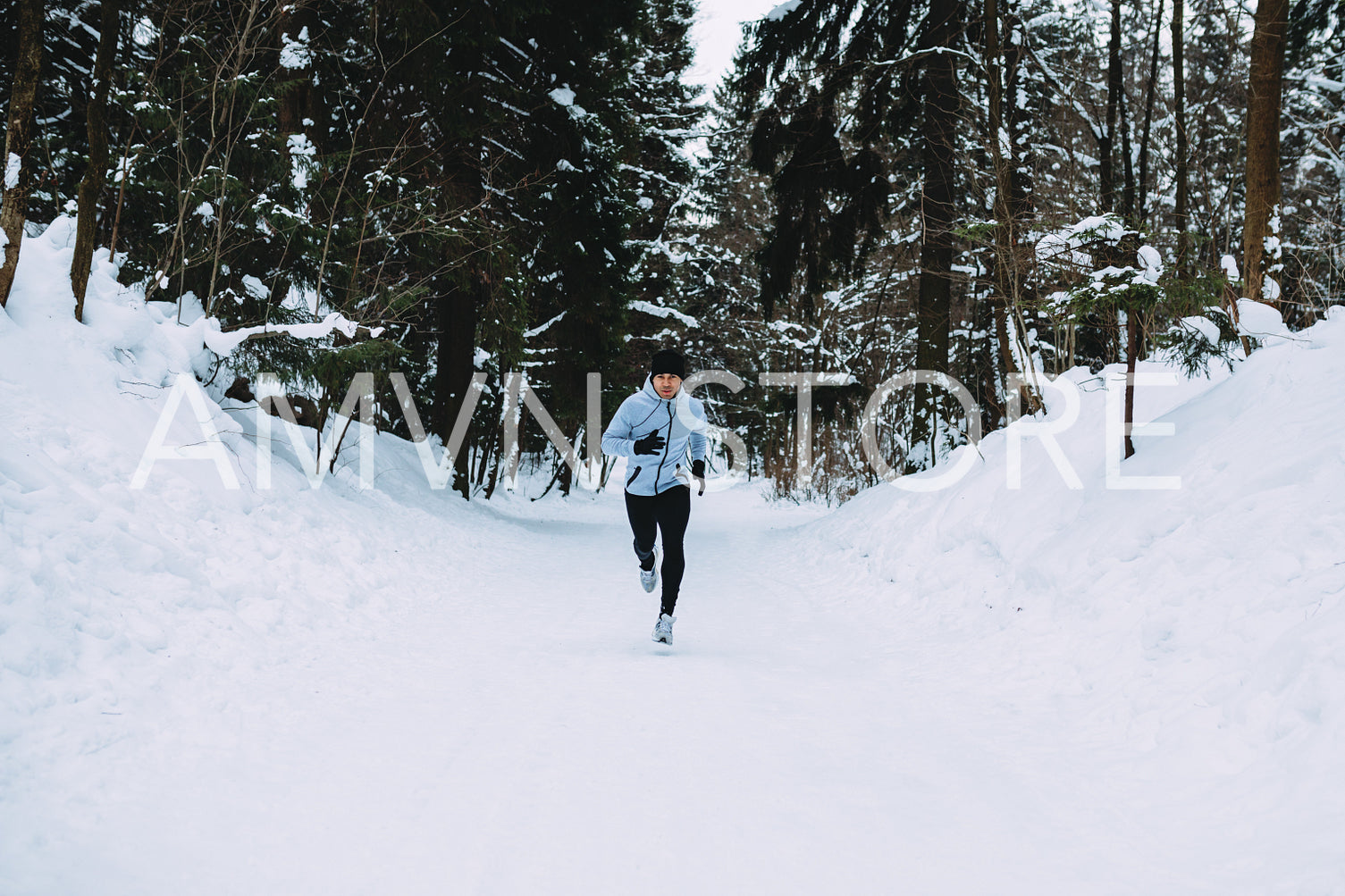 Sportsman running in forest. Young man exercising at winter.	
