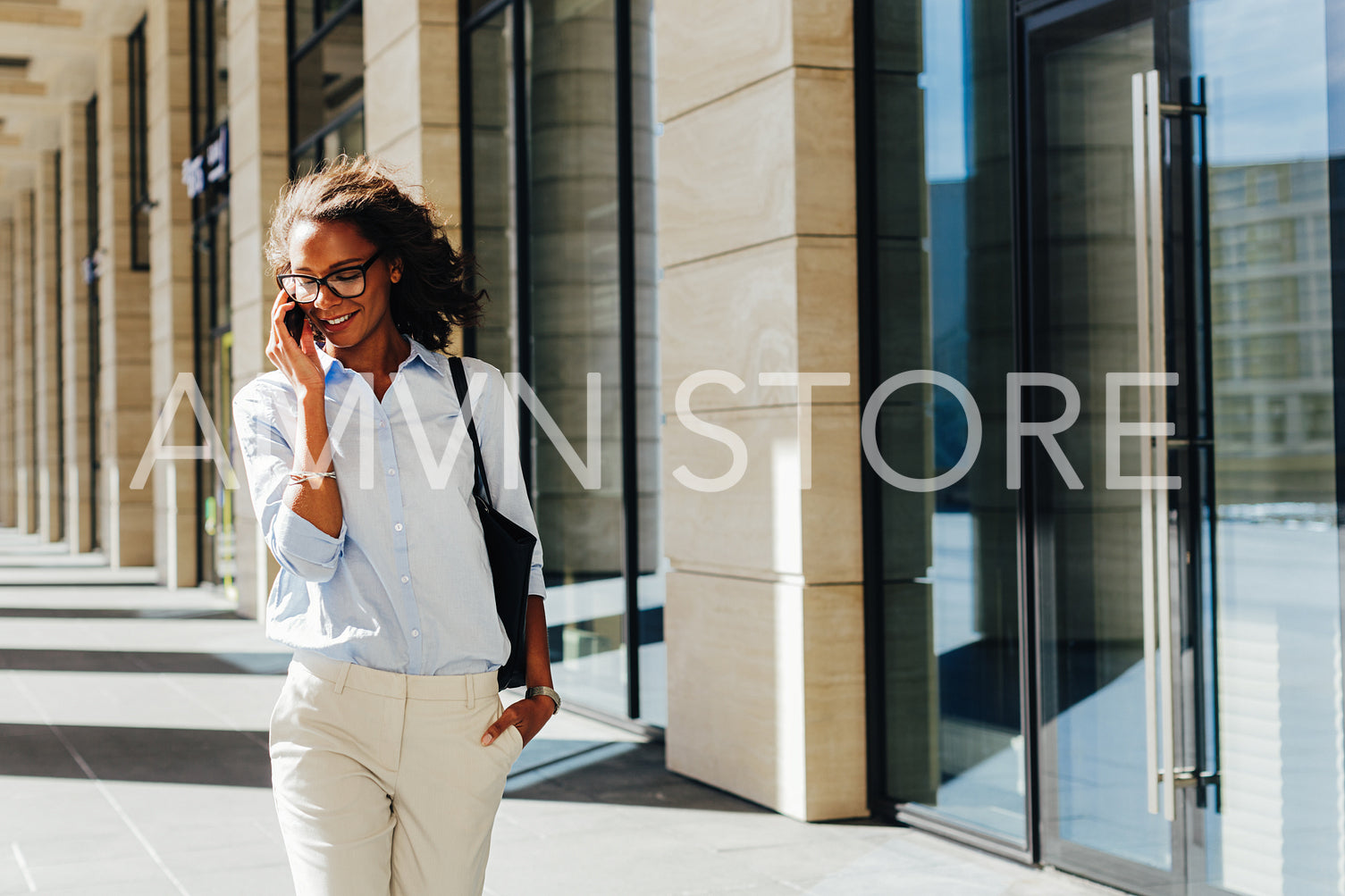 Woman walking at office building. Young entrepreneur talking on cell phone.	