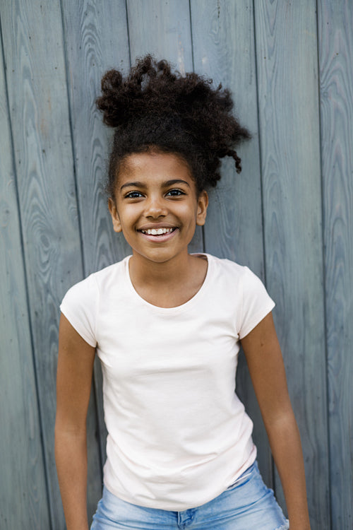 Portrait of little girl standing outdoors, wearing casual clothes