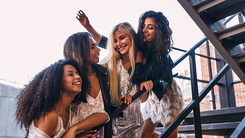 Laughing friends hugging together on the staircase in the city