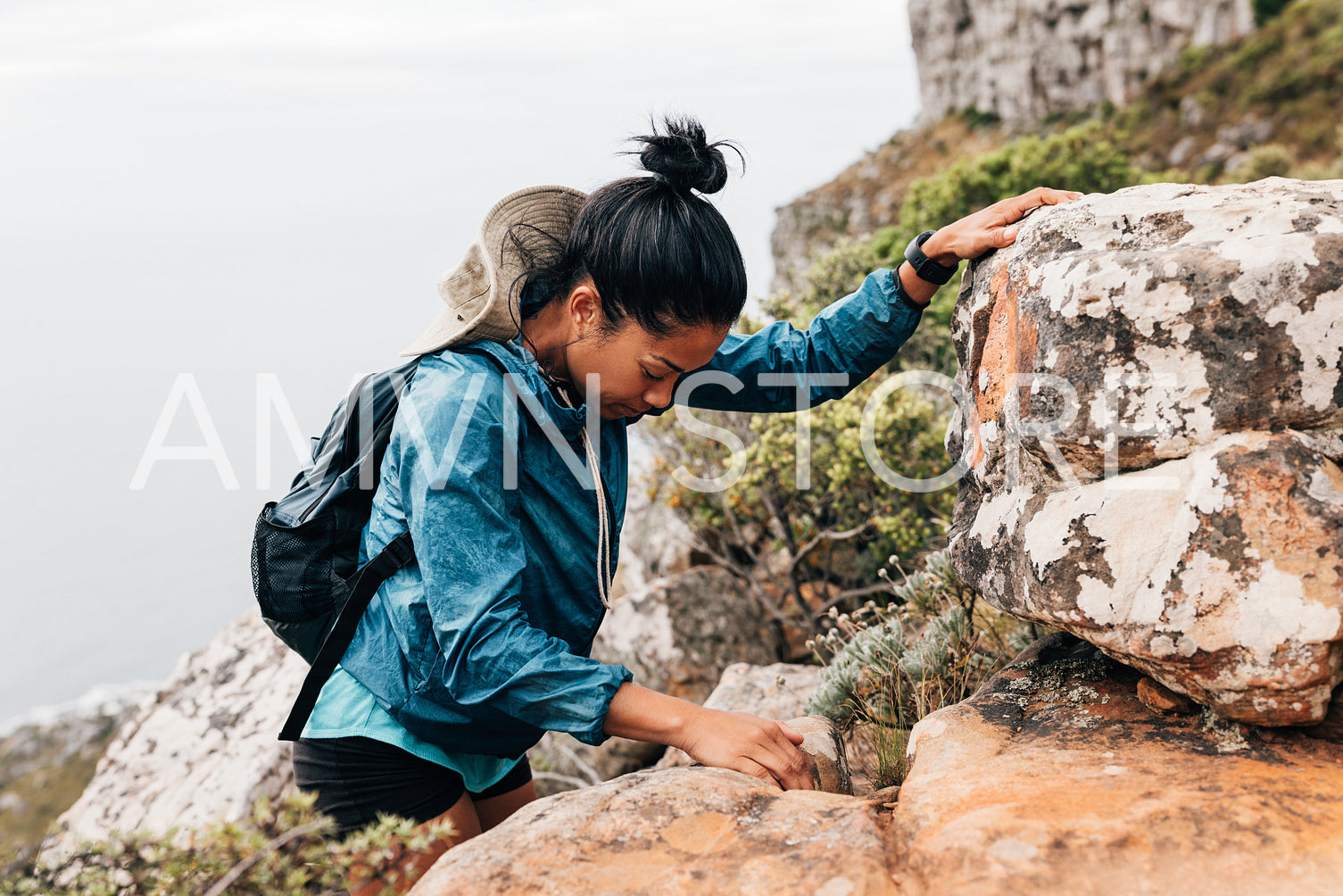 Woman hiker look where she steps while climbing up on a mountain