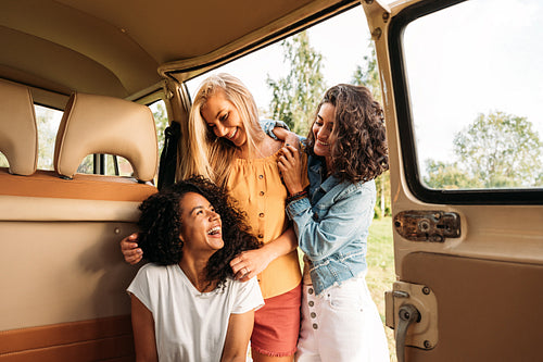 Three cheerful women having fun during road trip