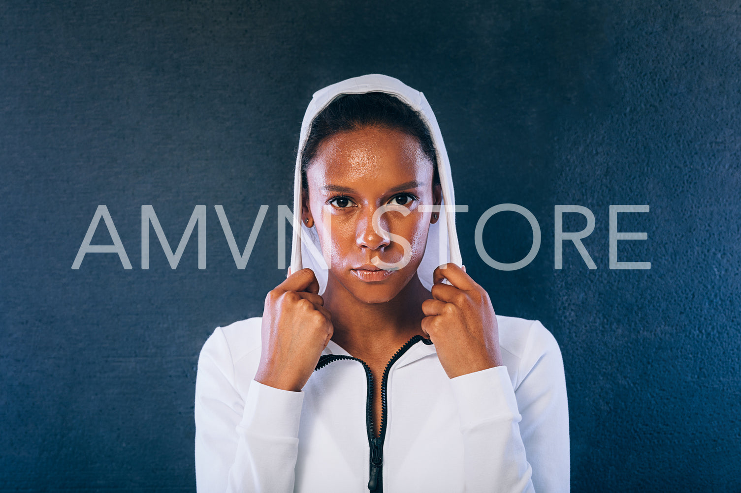 Young woman in sports clothes looking at camera. Confident and sweated sportswoman in studio.	