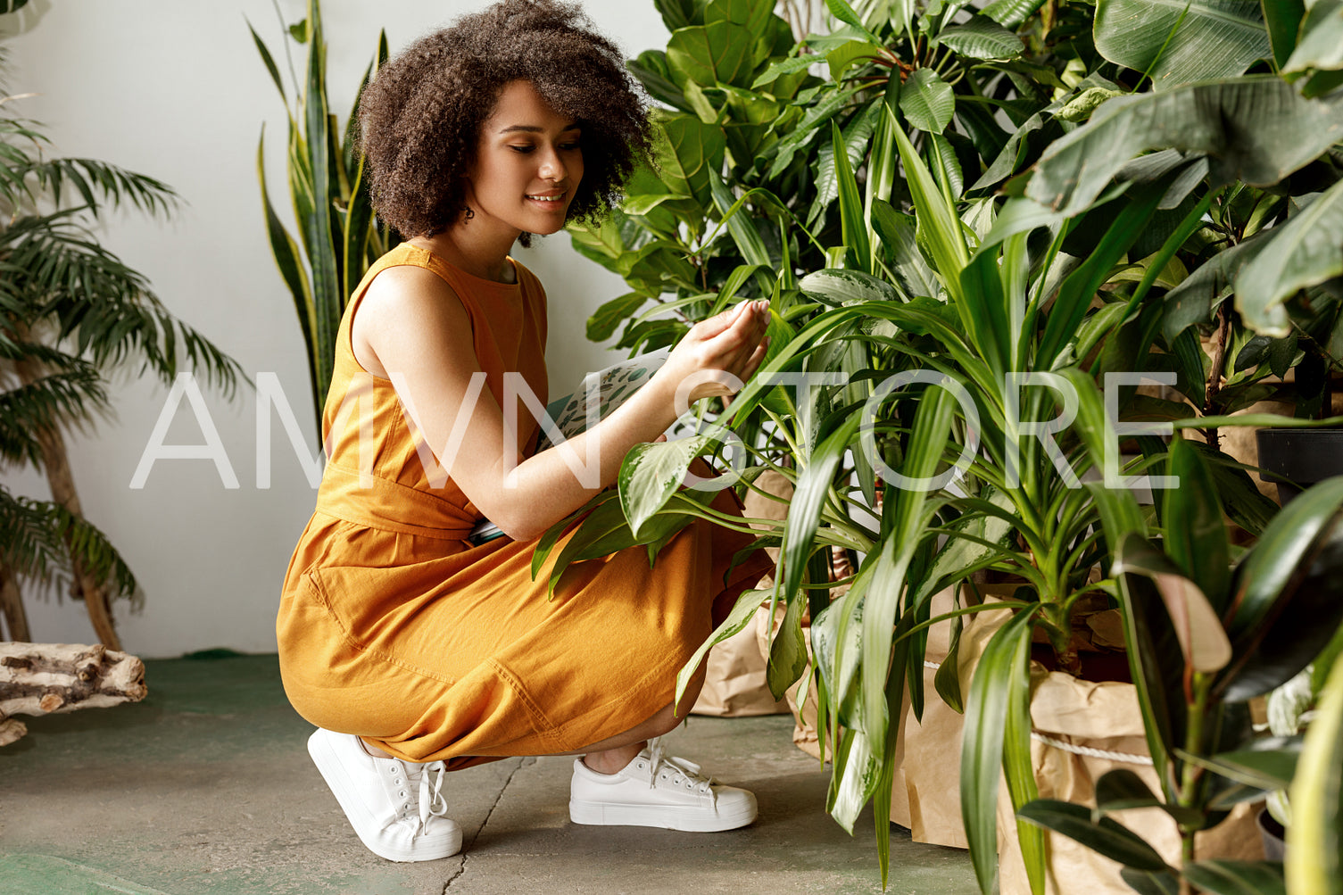 Young woman holding a book and observe a plant in workshop	