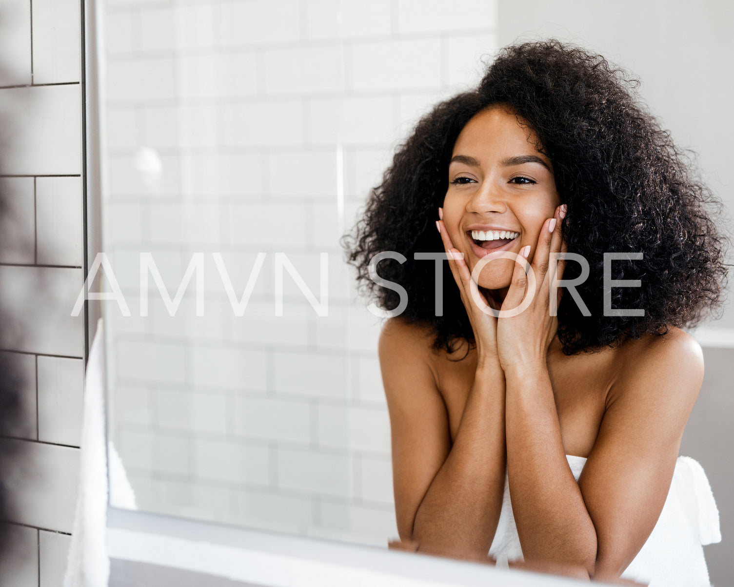 Happy woman admiring her skin in front of the bathroom mirror, touching face with hands	