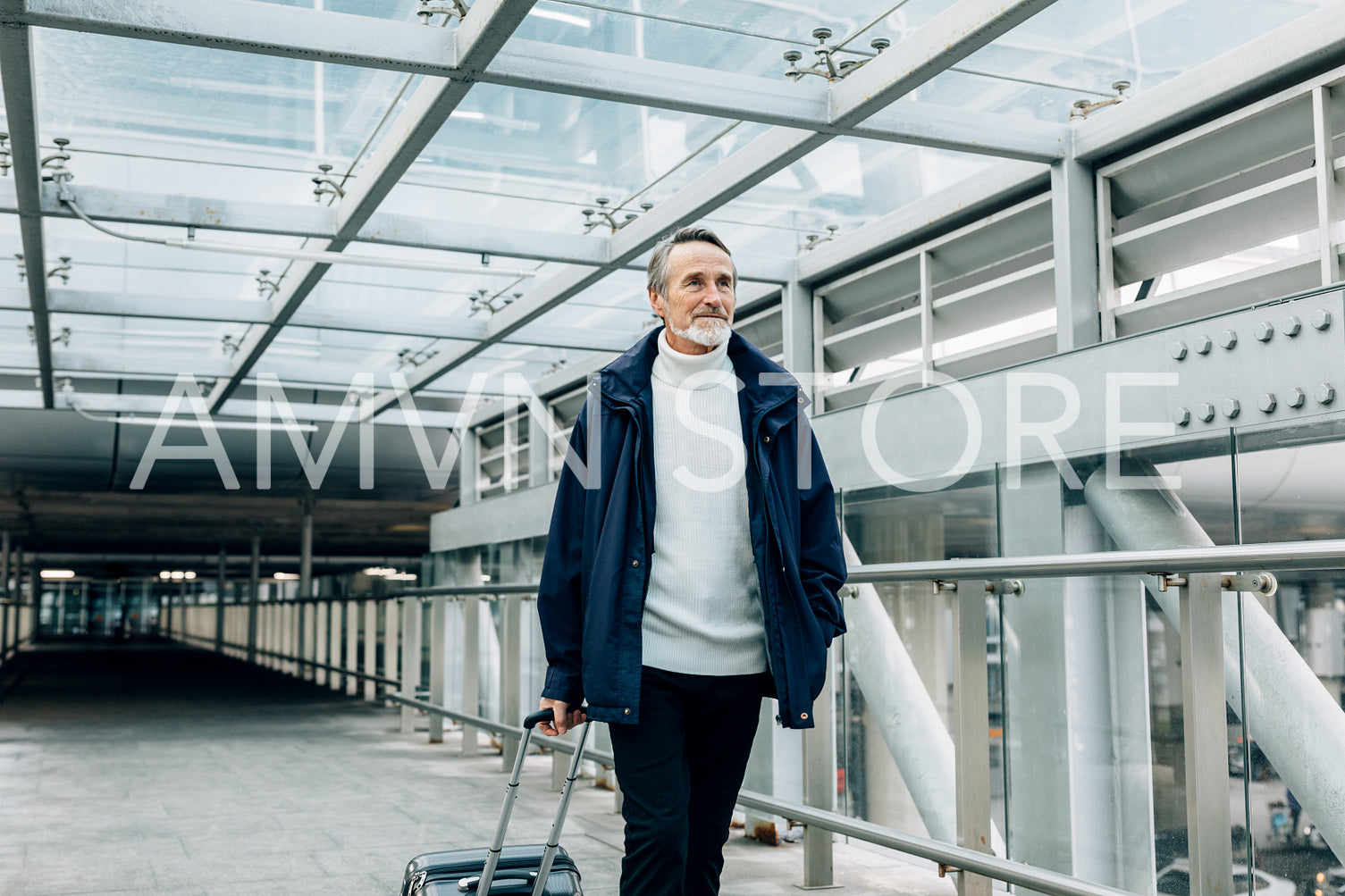 Handsome mature man walking with his luggage at airport	