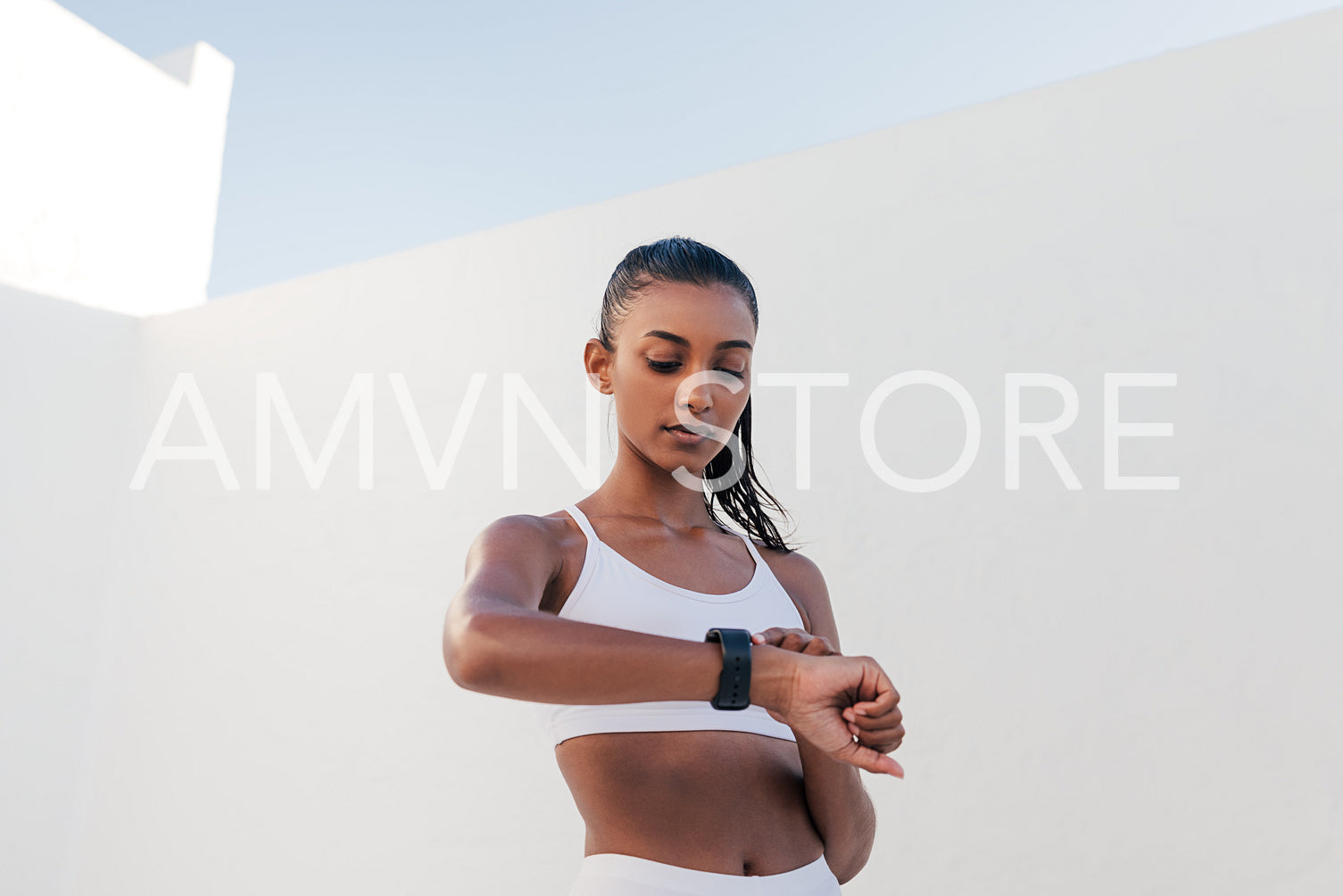 Slim female checking pulse on a smartwatch. Fitness influencer checking heart rate.