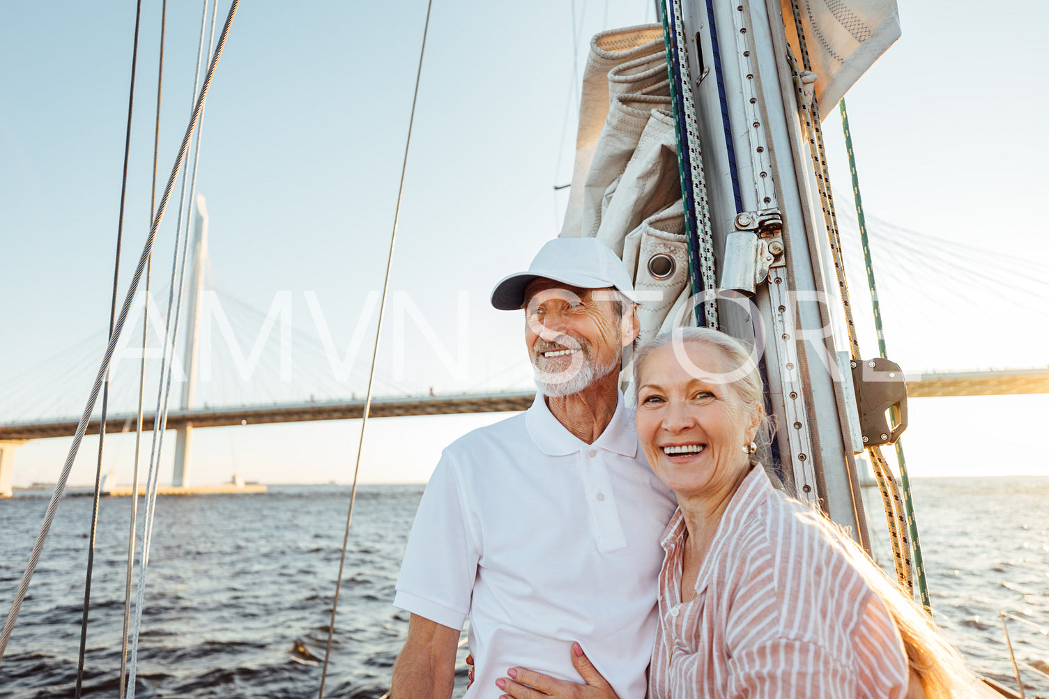 Happy senior couple standing at mast. Two smiling people enjoying boat trip.	