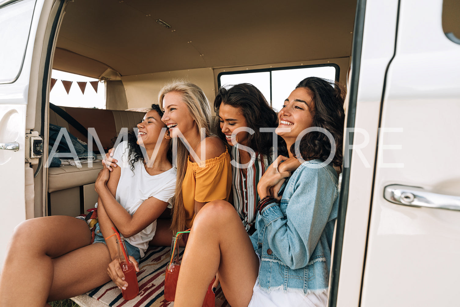 Four female friends on a road trip. Smiling and laughing women enjoying vacation.