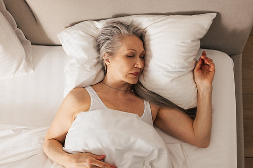 High angle of a senior woman sleeping in her bed