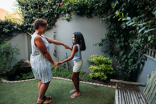 Granny and granddaughter dancing together at backyard