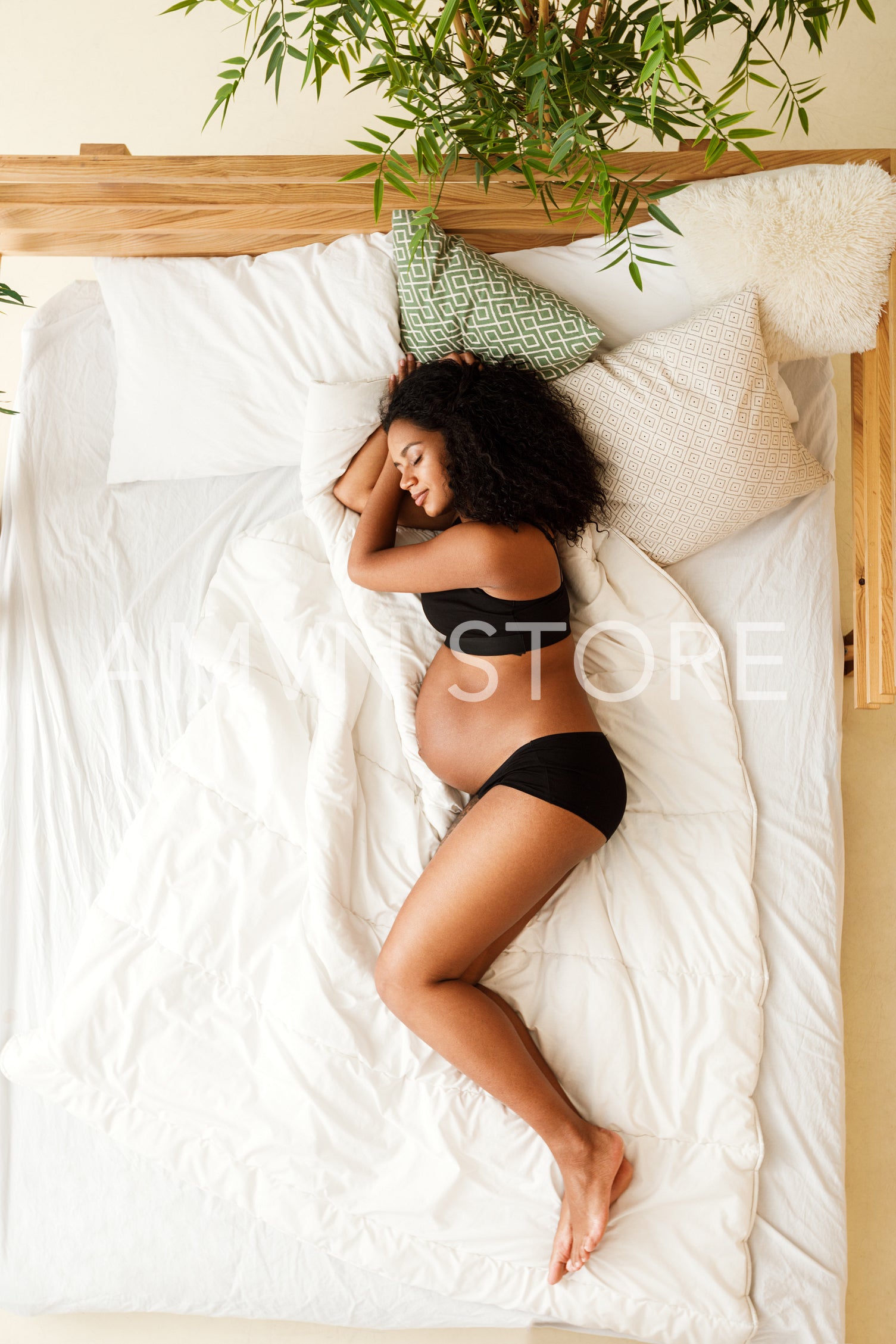 High angle view of a pregnant woman sleeping on bed	