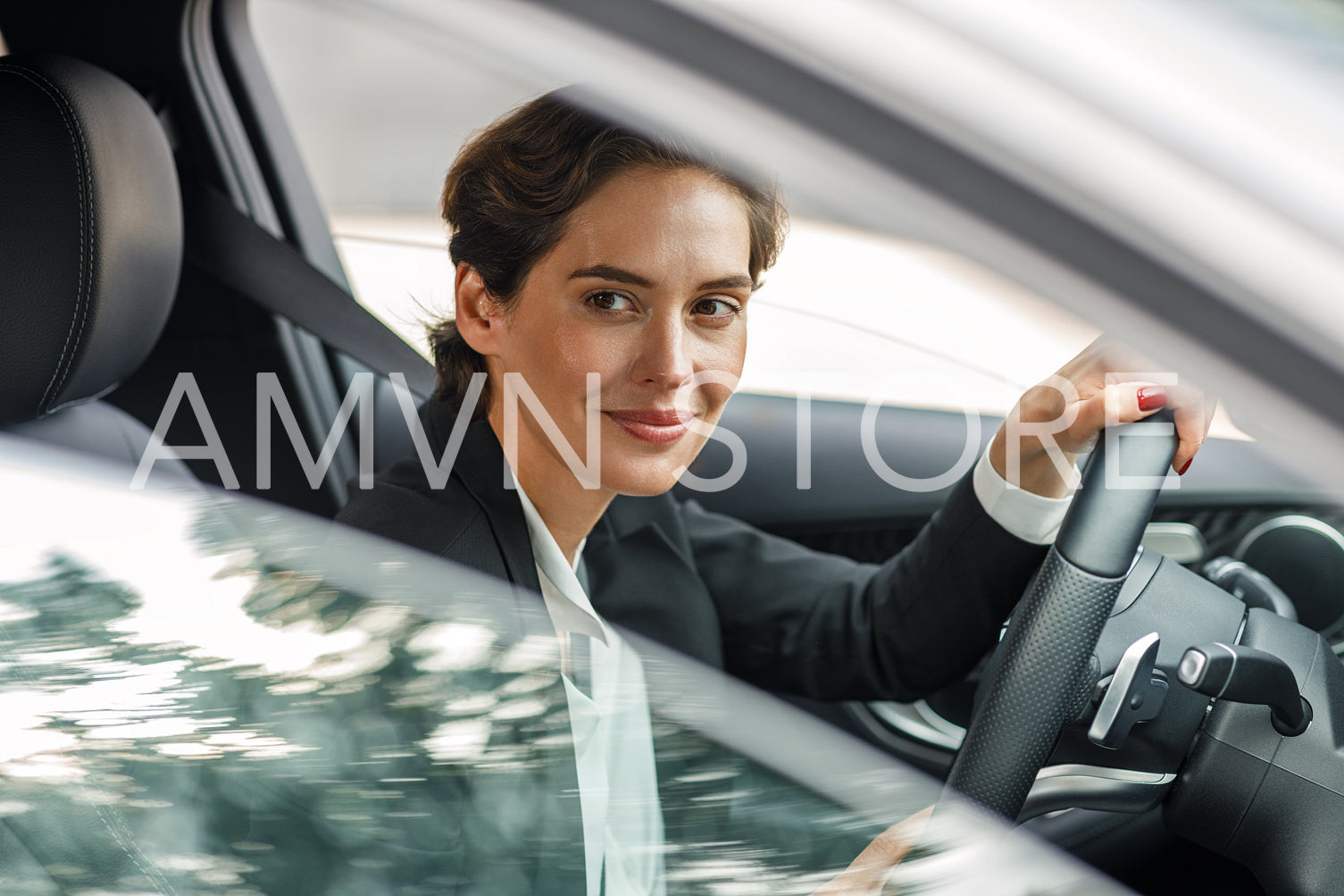 Side view of businesswoman driving car looking out of window. Portrait of a woman going to office in her car.	