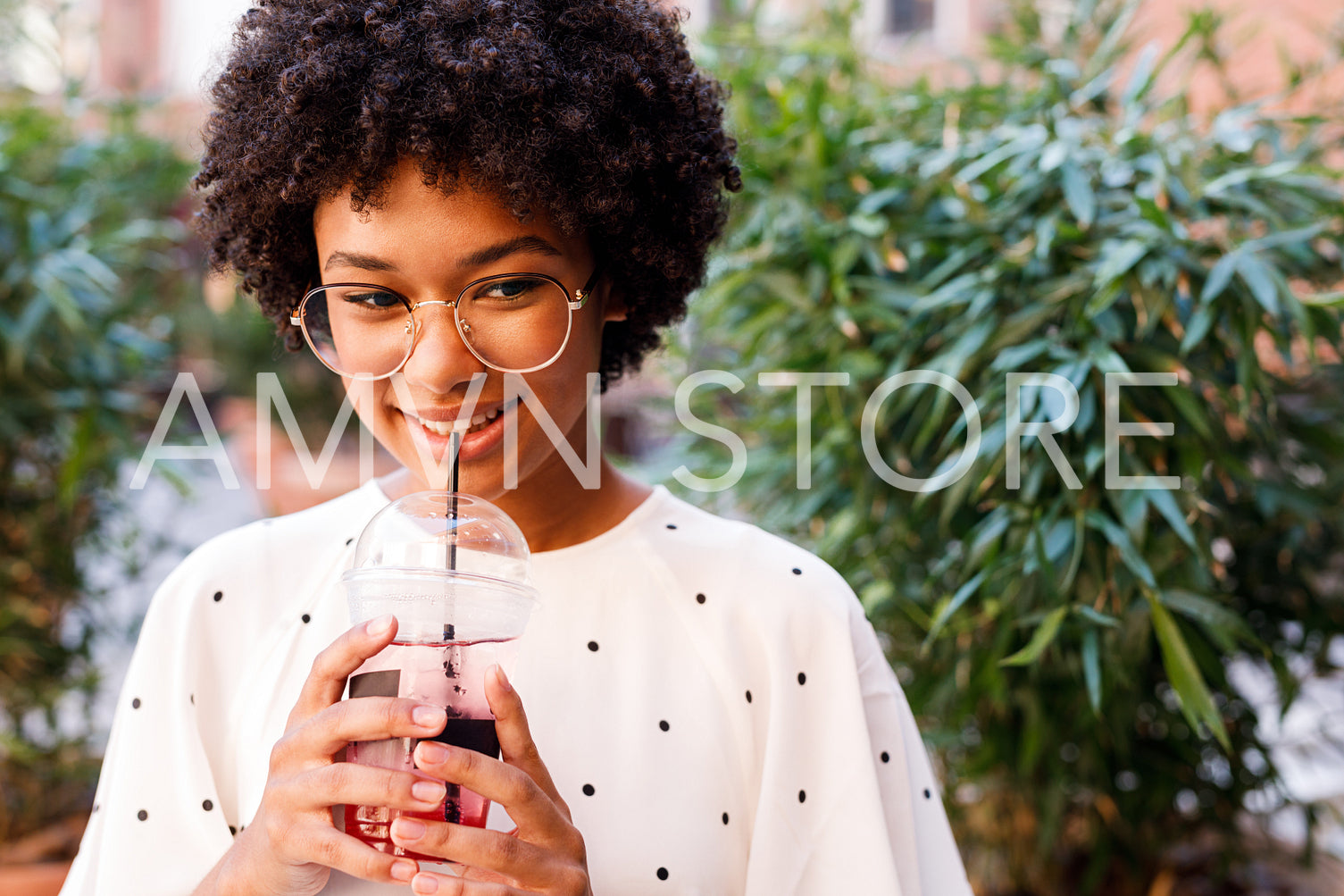 Portrait of a beautiful girl drinking juice with a straw	