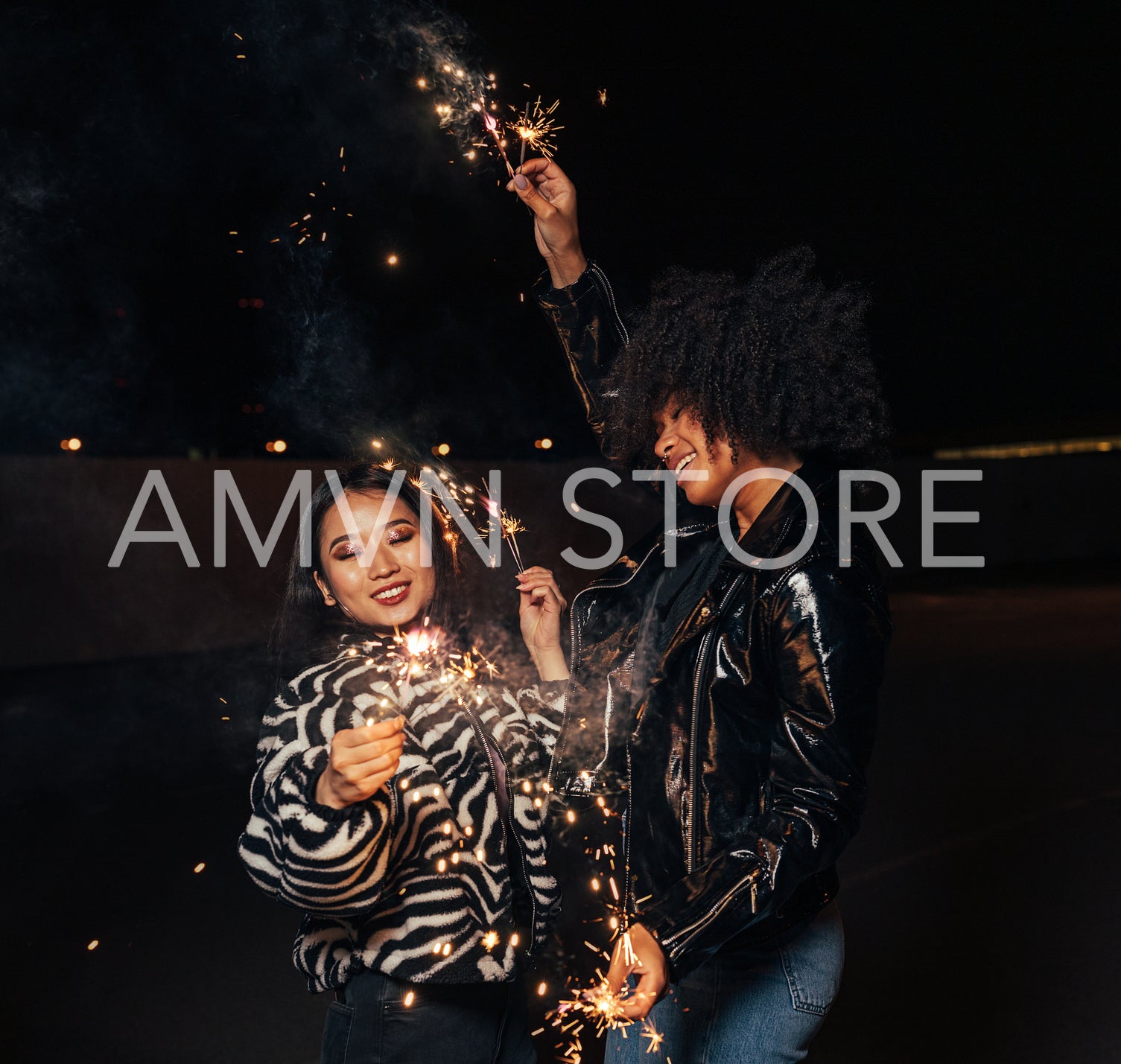 Two happy girls with sparklers enjoying a party at night	