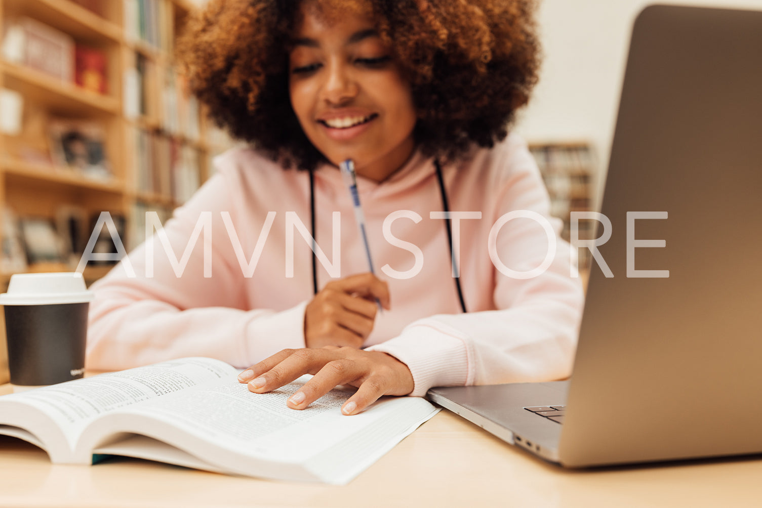 Close up of a girl sitting at desk in library and reading a book