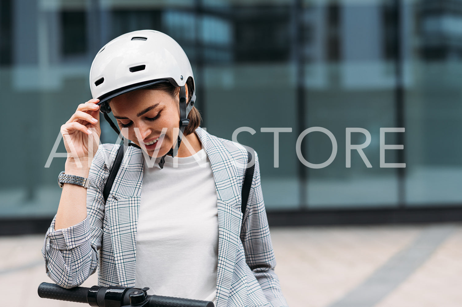 Portrait of a beautiful young woman with safety helmet looking down standing outdoors at office building