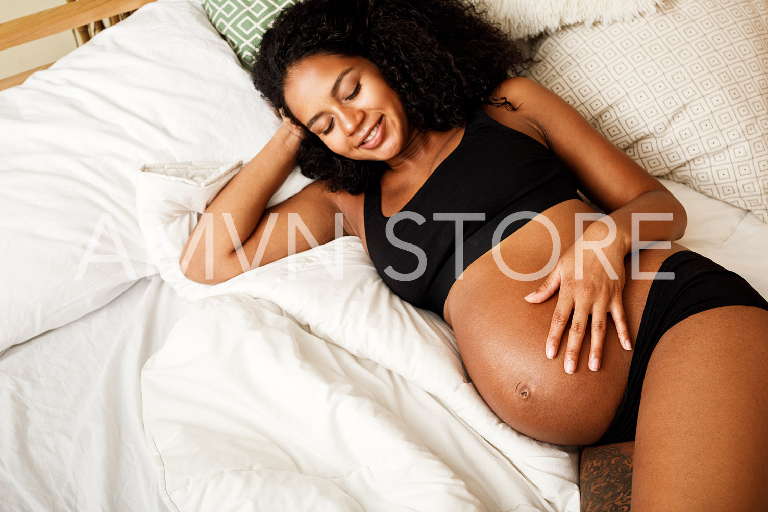 Young African American pregnant woman relaxing in bedroom	