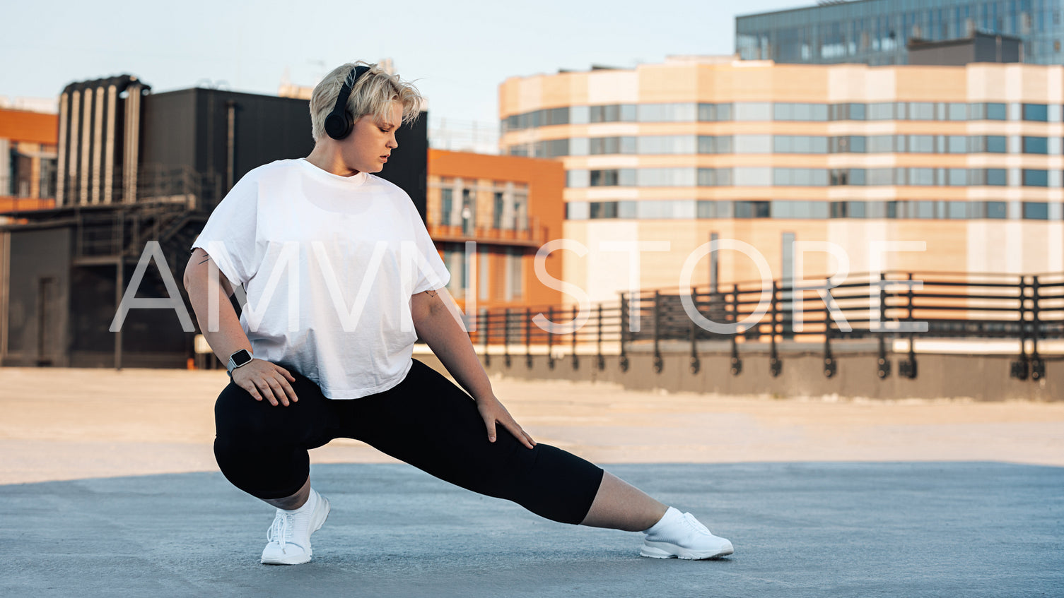 Plus size woman stretching her leg. Young curvy female exercising on roof.	