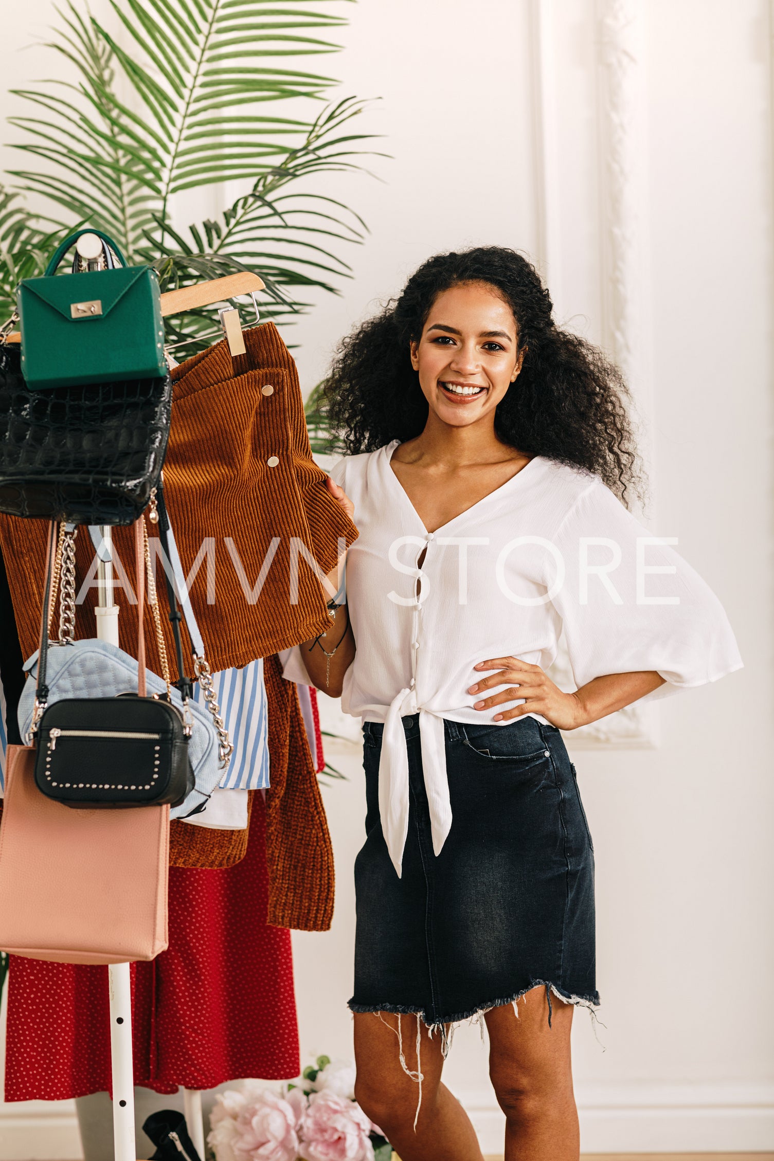 Fashion stylist posing at clothes rack	