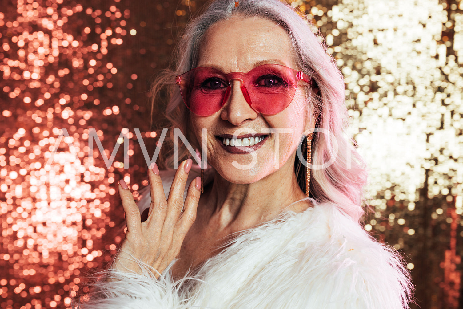 Close up of a smiling senior woman with grey hair wearing pink e