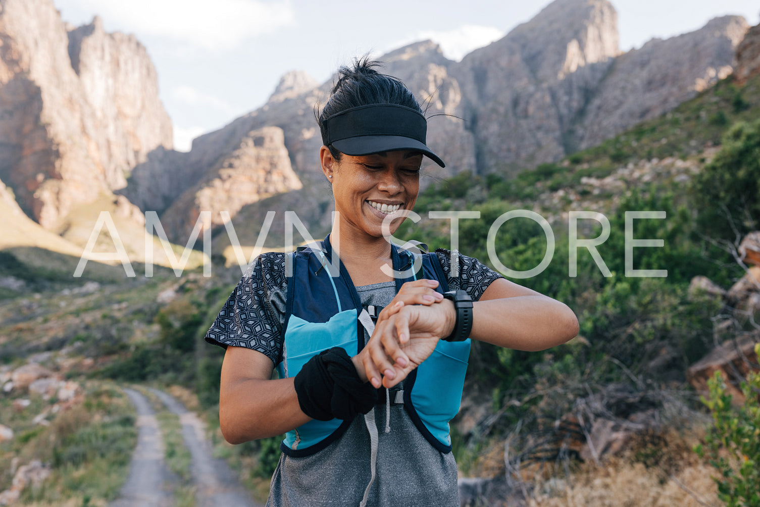 Smiling female taking a break during hike looking at smart watch