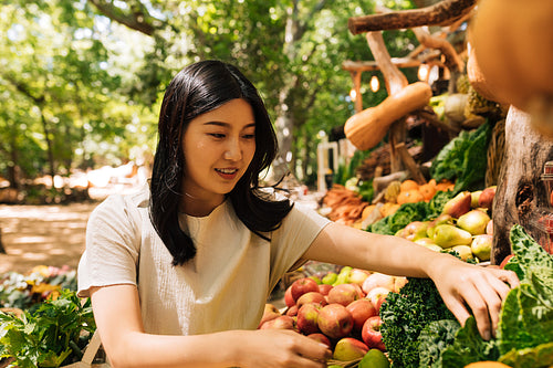 Young woman choosing lettuce on an outdoor market