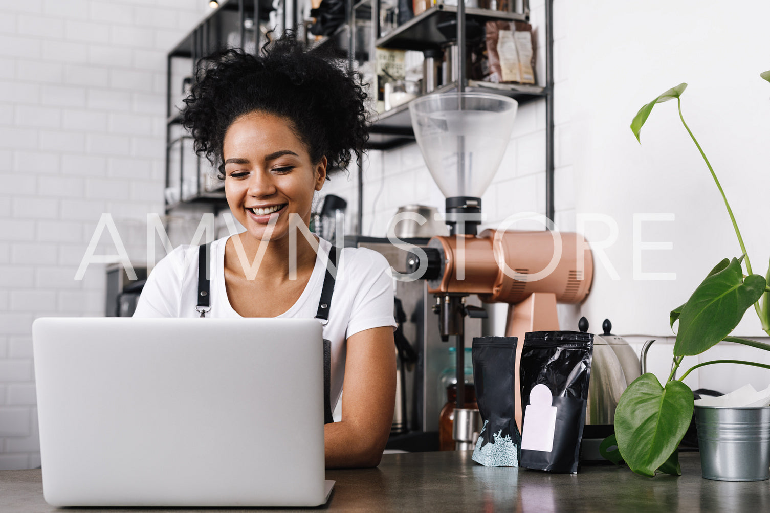 Young female cafe owner working on laptop	