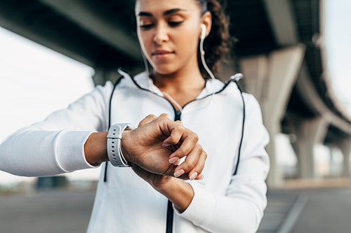 Close up of woman hand with a smart watch. Fit woman looking on activity tracker after work out.