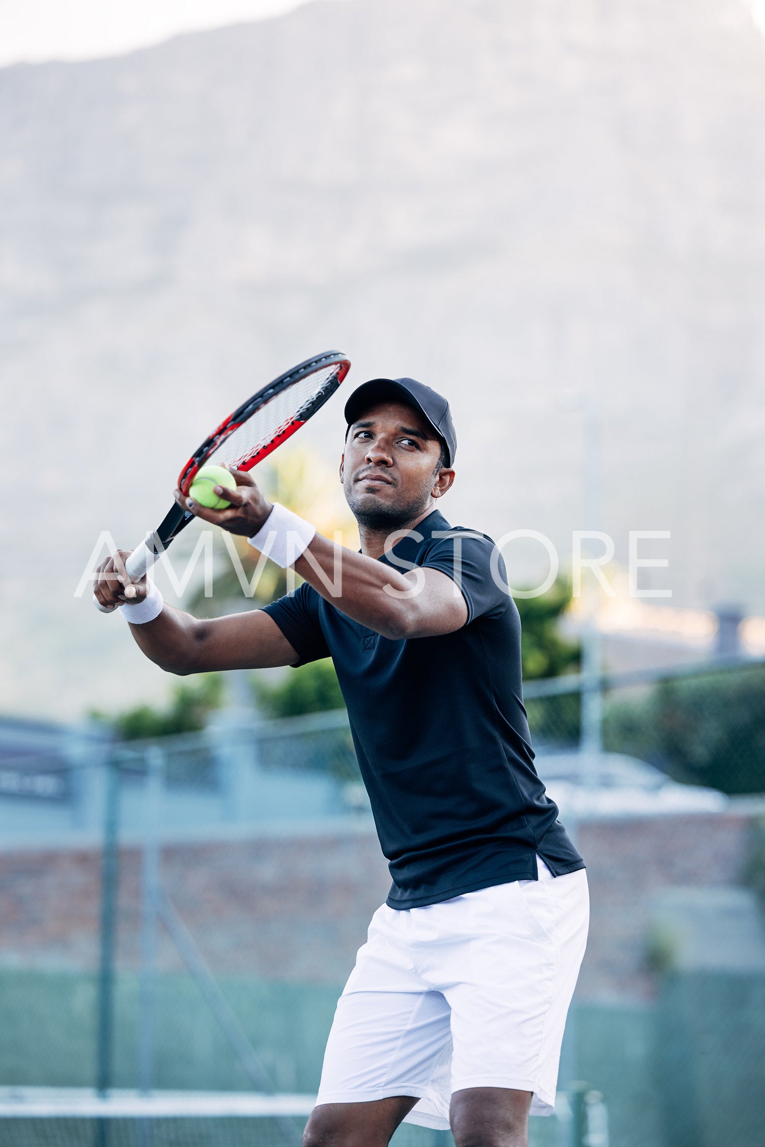 Young tennis athlete preparing to serve the ball in a game on an outdoor court