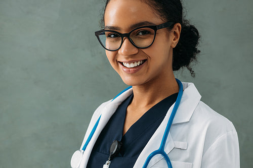 Portrait of a happy beautiful doctor with a stethoscope at a wall