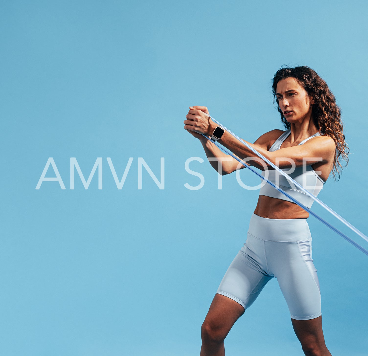 Slim woman in blue sportswear exercising with resistance band 