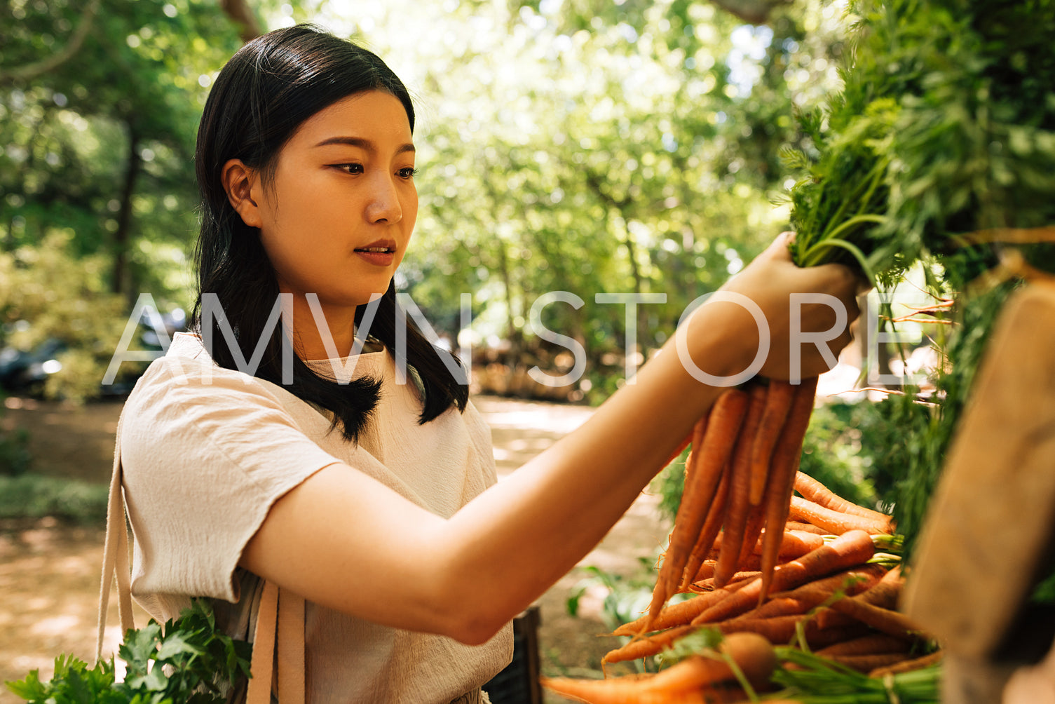 Young Asian woman choosing vegetables in a local outdoor market