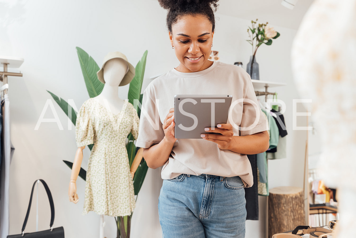 Local clothing store owner standing with digital tablet