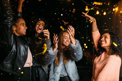 Happy women enjoying party at night, dancing on a terrace