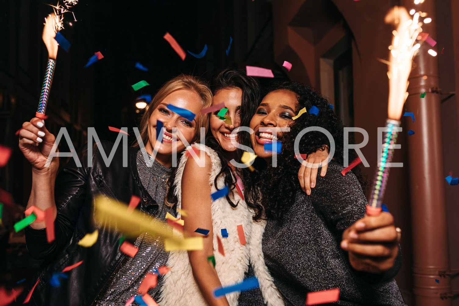 Friends having fun with confetti and sparklers at night city	